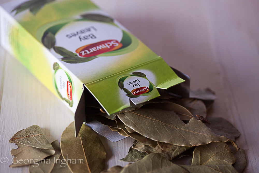 Dried bay leaves spilling from a Schwartz herb box &mdash; a classic aromatic used in roast chicken, sauces and slow-cooked dishes.